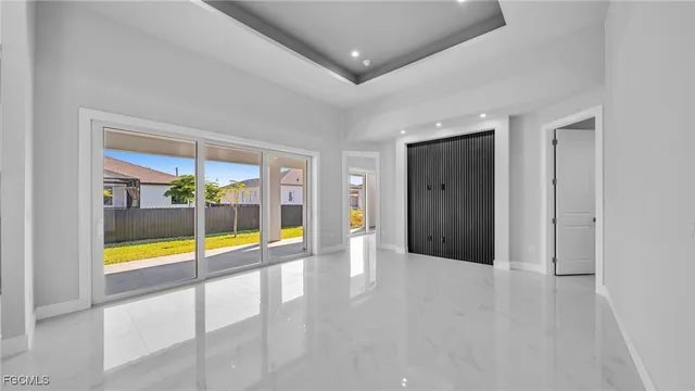 an empty room with floor to ceiling window and an outdoor view