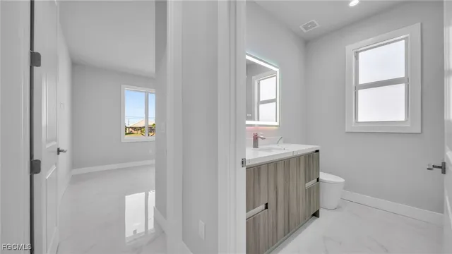 a bathroom with a sink toilet and window