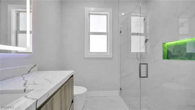 a bathroom with a sink a toilet and shower