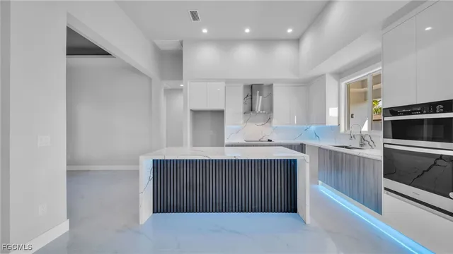 a kitchen with stainless steel appliances a sink stove and cabinets