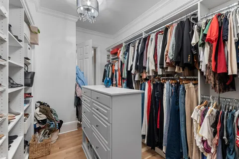 a dining room with wooden floor a chandelier a wooden table and chairs