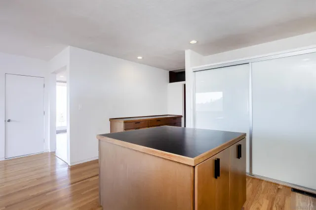 a kitchen with stainless steel appliances granite countertop a sink a refrigerator and a granite counter tops with wooden floors