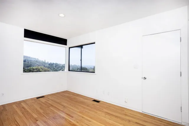 a view of big room with wooden floor and windows