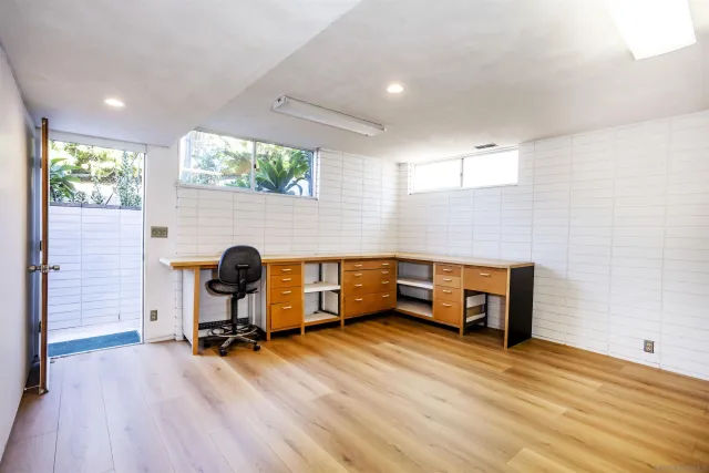 a view of a workspace with furniture and a wooden floor
