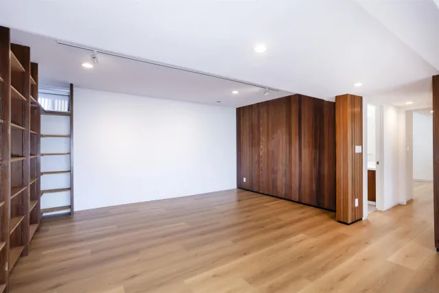 an empty room with wooden floor and closet