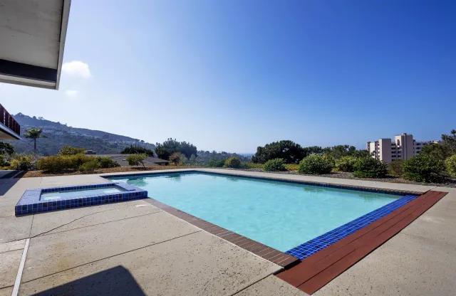 a view of swimming pool outdoor seating and mountain view