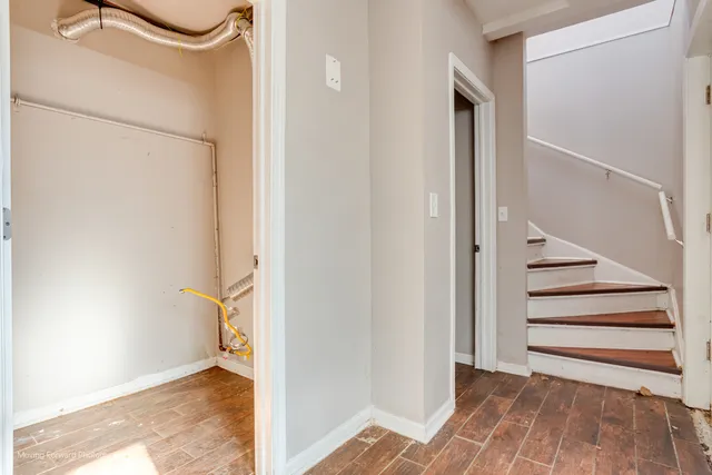 a view of a bedroom with wooden floor and white walls