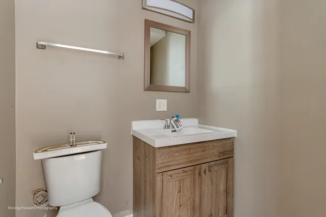 a bathroom with a toilet sink and mirror