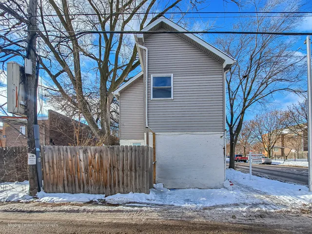 a view of a house with a wooden fence