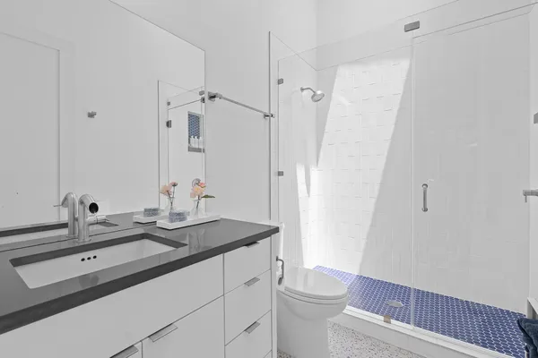 a bathroom with a sink a toilet a shower and a mirror