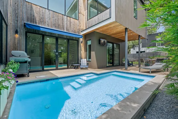 a view of a house with pool table and chairs next to a yard