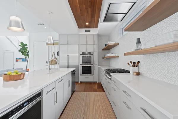 a kitchen that has a lot of cabinets in it and wooden floors