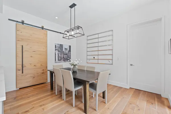 a kitchen with a dining table chairs wooden floor and appliances