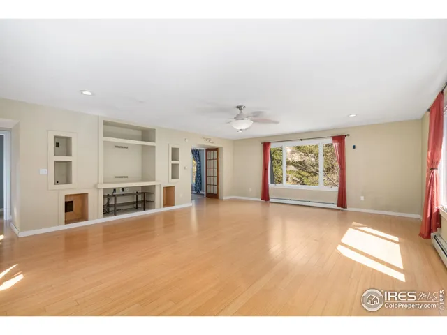 a view of a livingroom with wooden floor and a ceiling fan