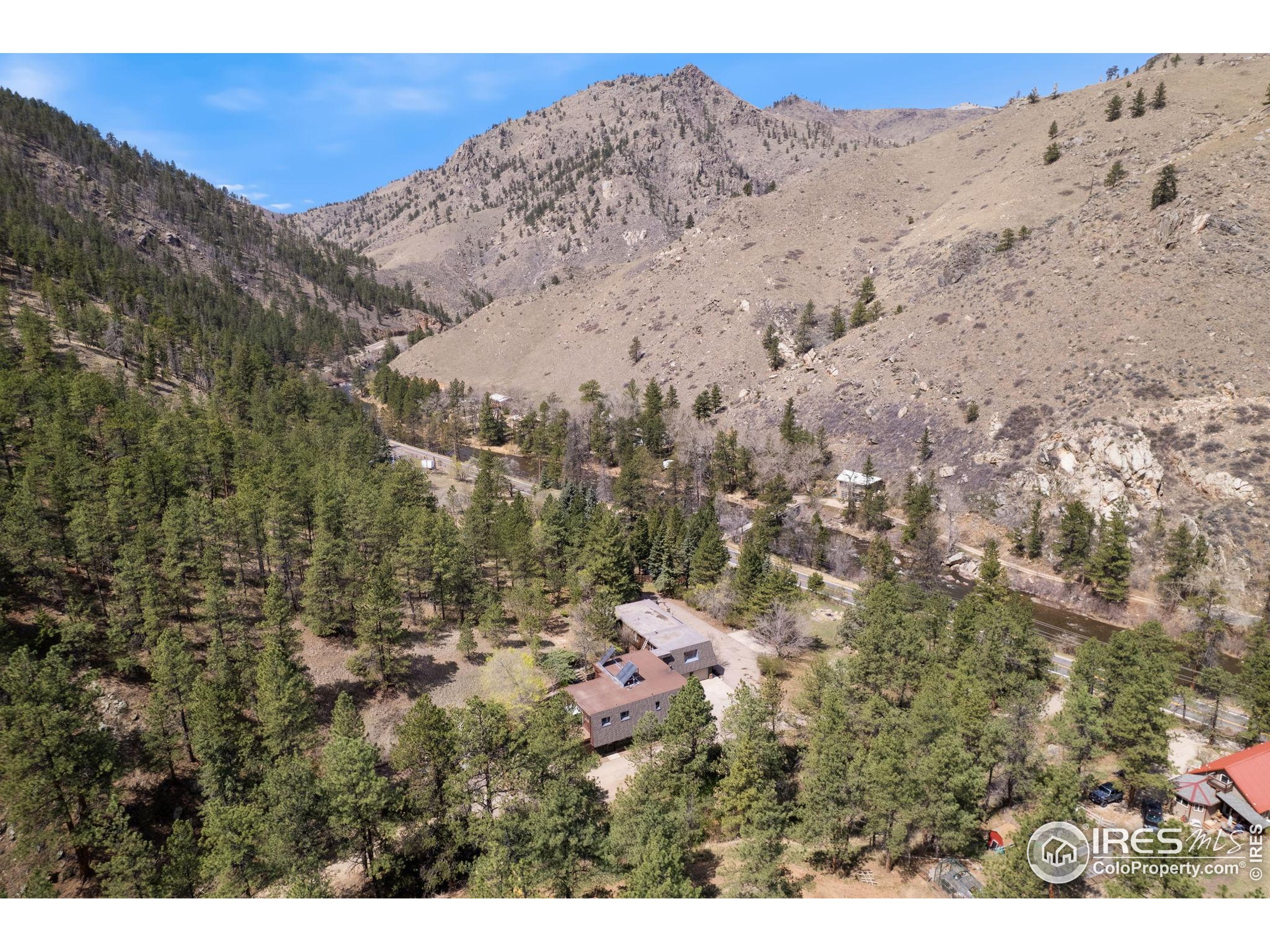 7301 Poudre Canyon Road Bellvue, CO 80512 - Photo 6 of 41 a view of a dry yard with mountains in the background