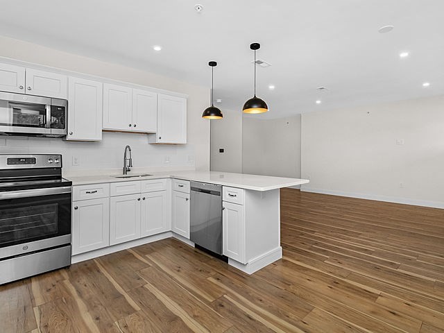 1 Pleasant Street, Unit 305 Cohasset, MA 02025 - Photo 8 of 24 a kitchen with a sink stainless steel appliances and cabinets