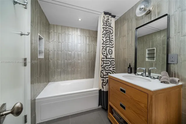 a bathroom with a tub sink and mirror