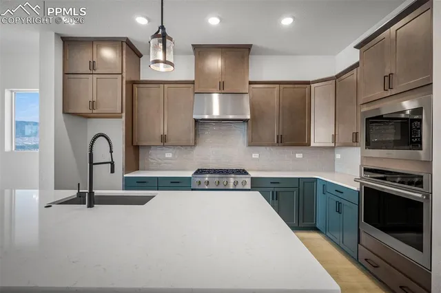 a kitchen with stainless steel appliances granite countertop a sink stove a refrigerator and cabinets with wooden floor