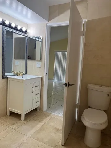 a bathroom with a sink and mirror with toilet