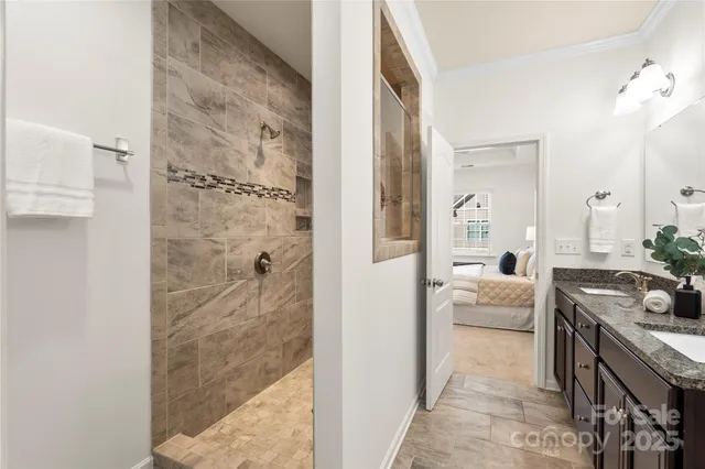 a en suite bathroom with a granite countertop sink a mirror and shower