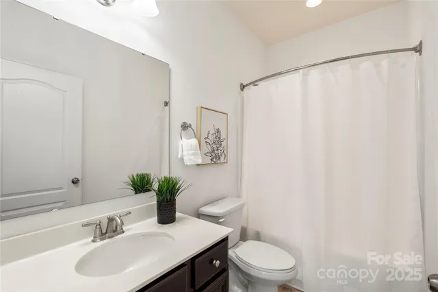 a bathroom with a sink toilet and a mirror