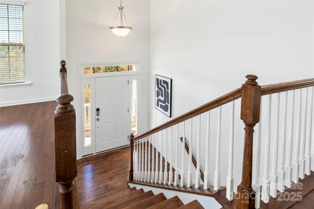 a view of a hallway with wooden floor and staircase