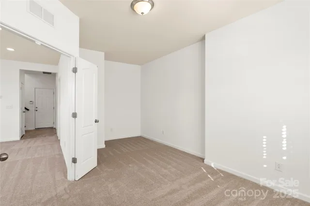 an empty room with white cabinet and a bathroom