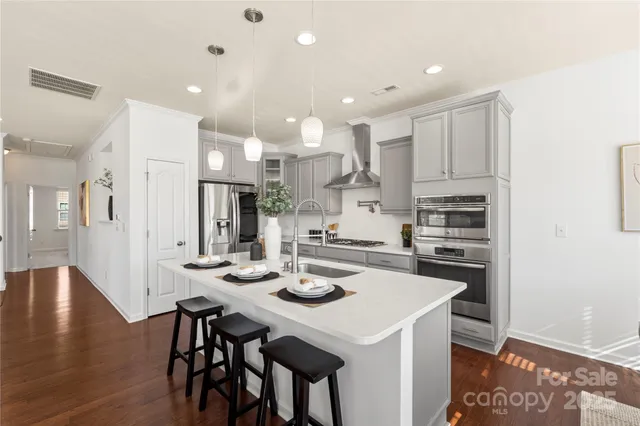 a kitchen with stainless steel appliances kitchen island granite countertop a kitchen island a stove a table and chairs