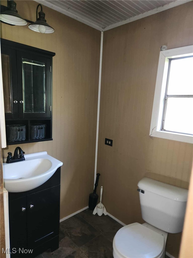 51036 Rochester Road Pleasant City, OH 43772 - Photo 8 of 22 Half bath featuring vanity and wood walls