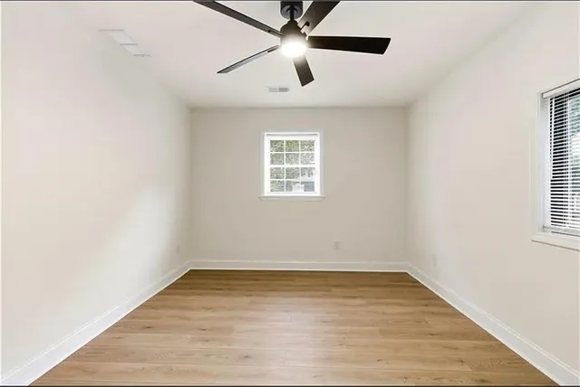 an empty room with a window and a ceiling fan
