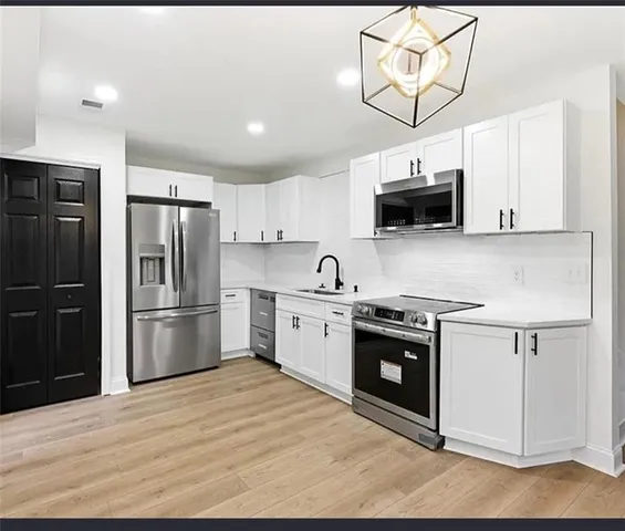 a kitchen with stainless steel appliances a refrigerator a stove top oven a sink and dishwasher