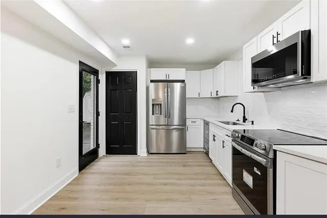 a kitchen with stainless steel appliances granite countertop a refrigerator stove a sink dishwasher and microwave oven with cabinets