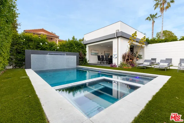 a kitchen with stainless steel appliances a stove top oven a sink dishwasher and a dining table with wooden floor