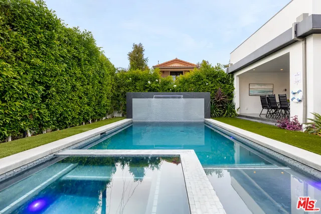 a living room with furniture kitchen view and a large window