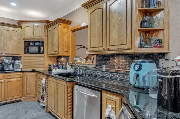 a kitchen with granite countertop a stove and cabinets