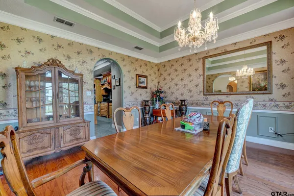 a dining room with furniture a chandelier and wooden floor