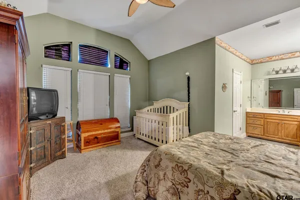 a bedroom with a bed and a large mirror