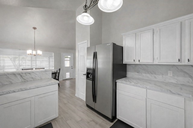 29206 Stapleford Street Spring, TX 77386 - Photo 8 of 22 a kitchen with stainless steel appliances kitchen island granite countertop a refrigerator a sink dishwasher a stove and white cabinets with wooden floor