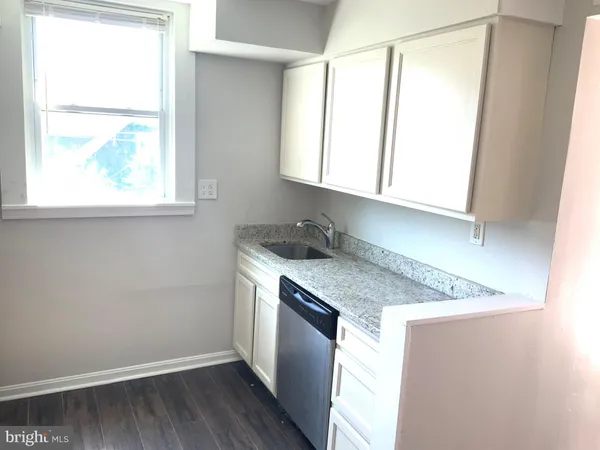 a kitchen with granite countertop cabinets stainless steel appliances a sink and a window