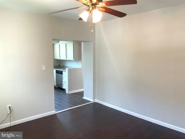 an empty room with wooden floor closet and windows