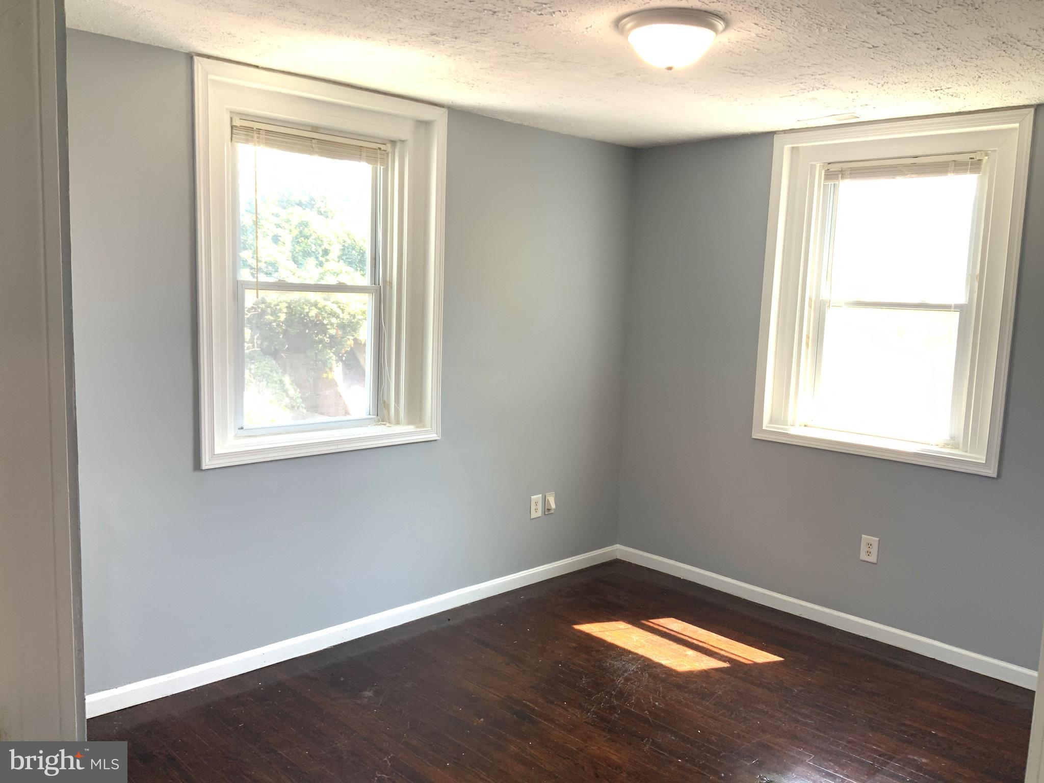 6209 York Road, Unit A Baltimore, MD 21212 - Photo 20 of 31 a view of an empty room with wooden floor and a window