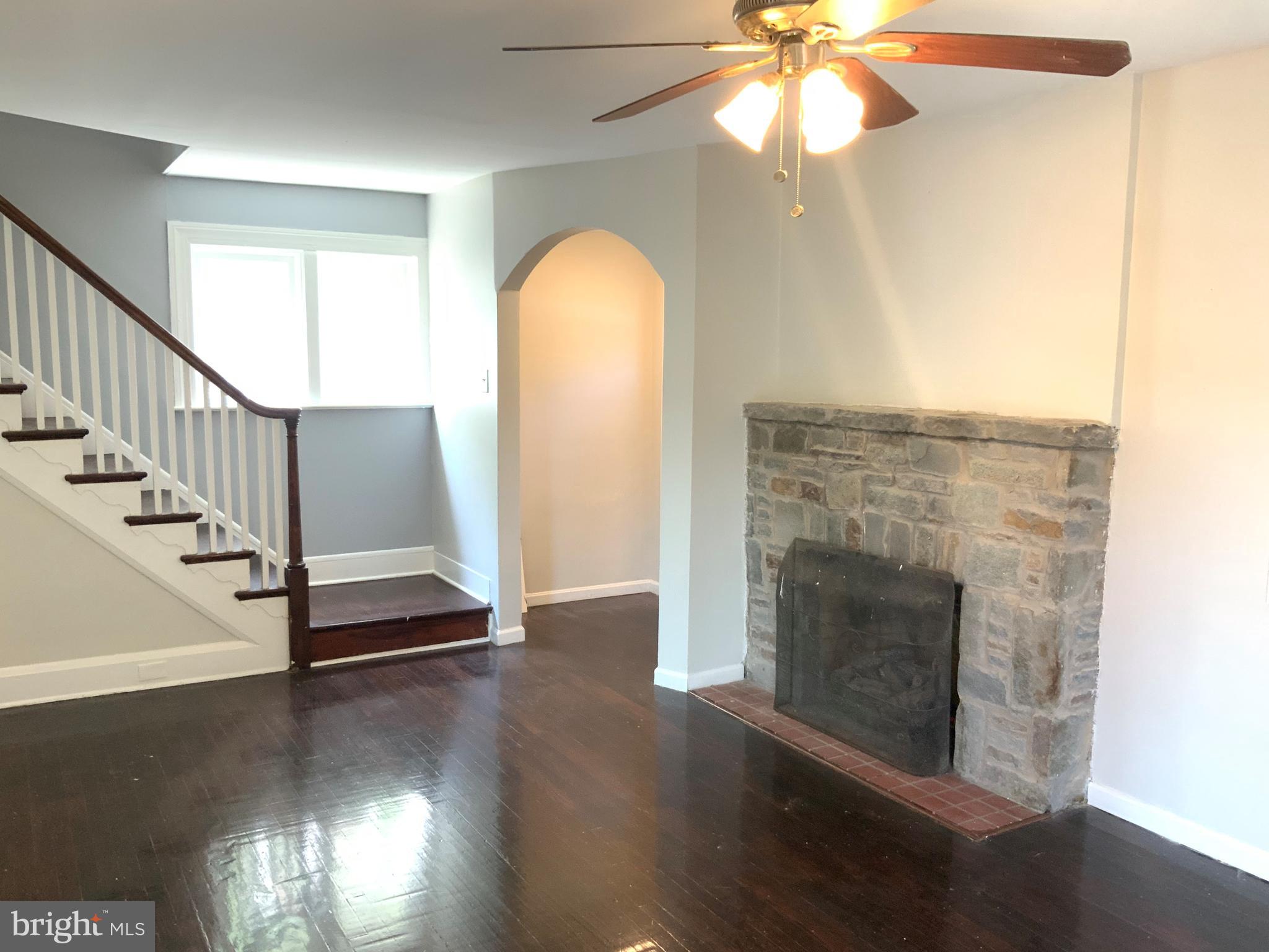 6209 York Road, Unit A Baltimore, MD 21212 - Photo 3 of 31 a view of a livingroom with wooden floor a fireplace a ceiling fan and a window