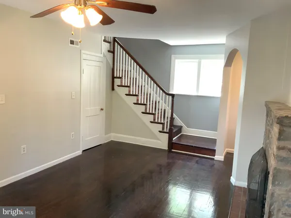a view of a livingroom with wooden floor and a staircase