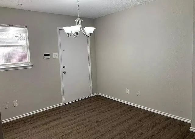 a view of a room with wooden floor and chandelier