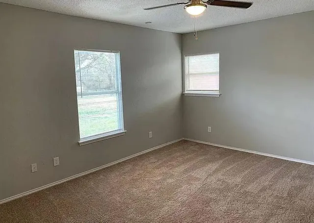 a bathroom with a granite countertop toilet a sink and a mirror