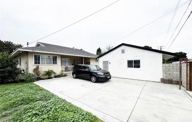a white house that has a car parked in front of it