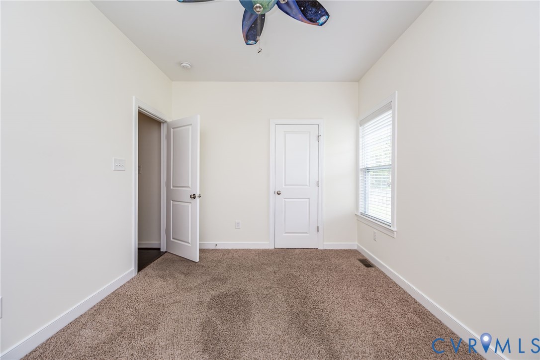 11224 Hill Ridge Court Ashland, VA 23005 - Photo 23 of 35 an empty room with windows and ceiling fan view