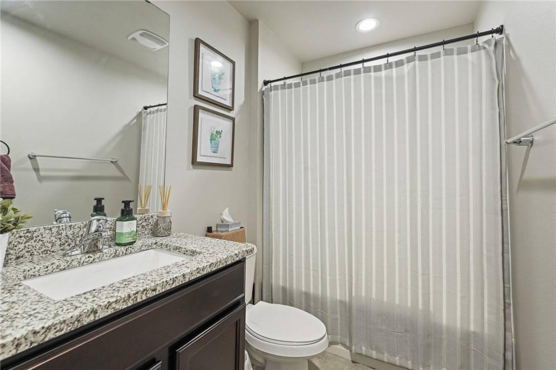 103 Donegal Street Sinton, TX 78387 - Photo 15 of 29 a bathroom with a granite countertop sink toilet and a mirror