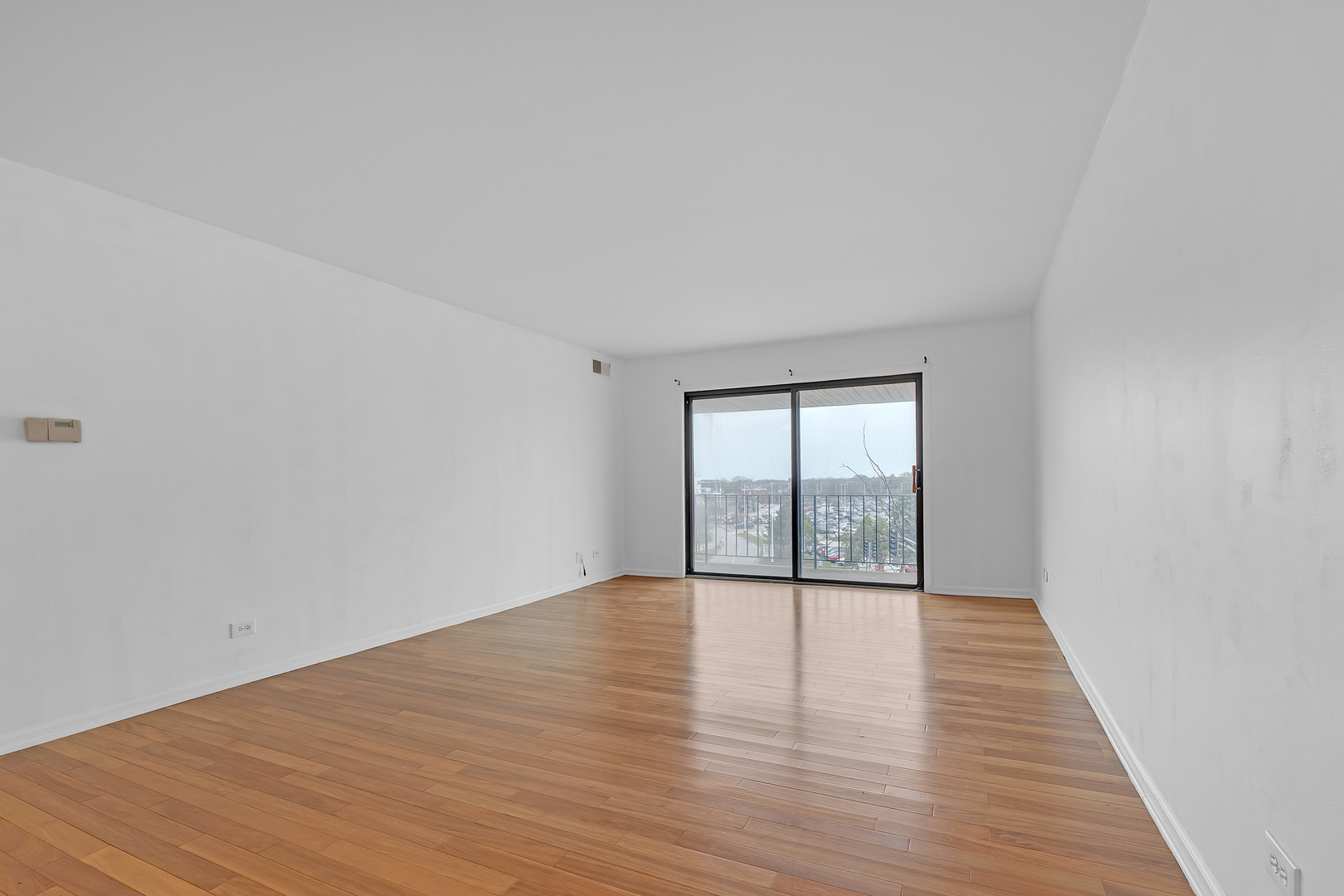 4901 Golf Road, Unit 410 Skokie, IL 60077 - Photo 6 of 26 wooden floor in an empty room with a window