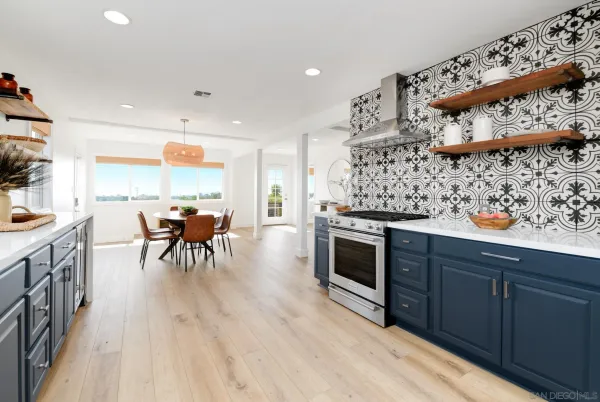 a kitchen with stainless steel appliances wooden floors wooden table and chairs
